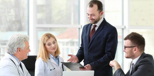 Young businessman presents information to doctors
