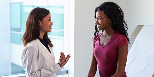 Young female NP talks to young black female patient