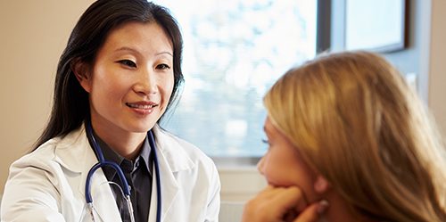 Female Asian NP treats blonde adolescent female