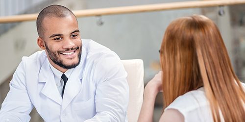 Young male doctor consulting with a patient