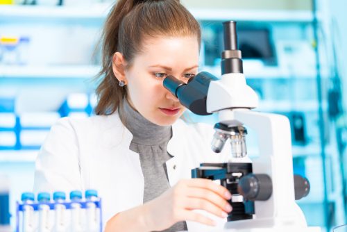 (Image 1) An epidemiologist looks into a microscope