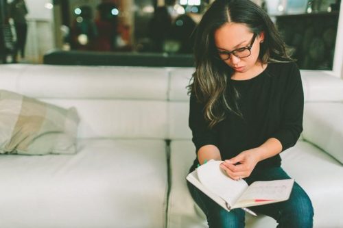 An online MST student reviews class notes in a notebook.