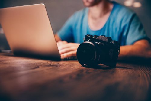 Man uploads images or video to his laptop from his camera.