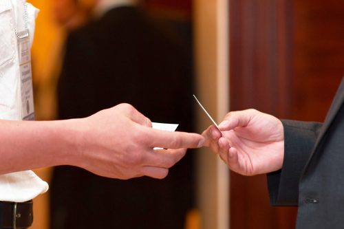 Two students exchange business cards.