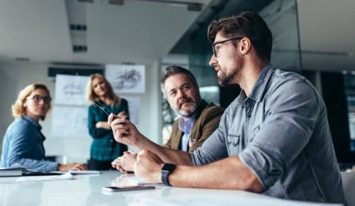 Low-angle of a group of people wearing casual clothes in a meeting in a conference room.