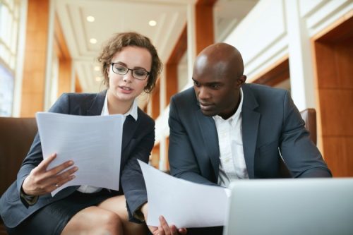 Two public administrators discuss a policy paper.