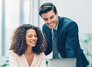 Black woman and caucasian man working together on a laptop