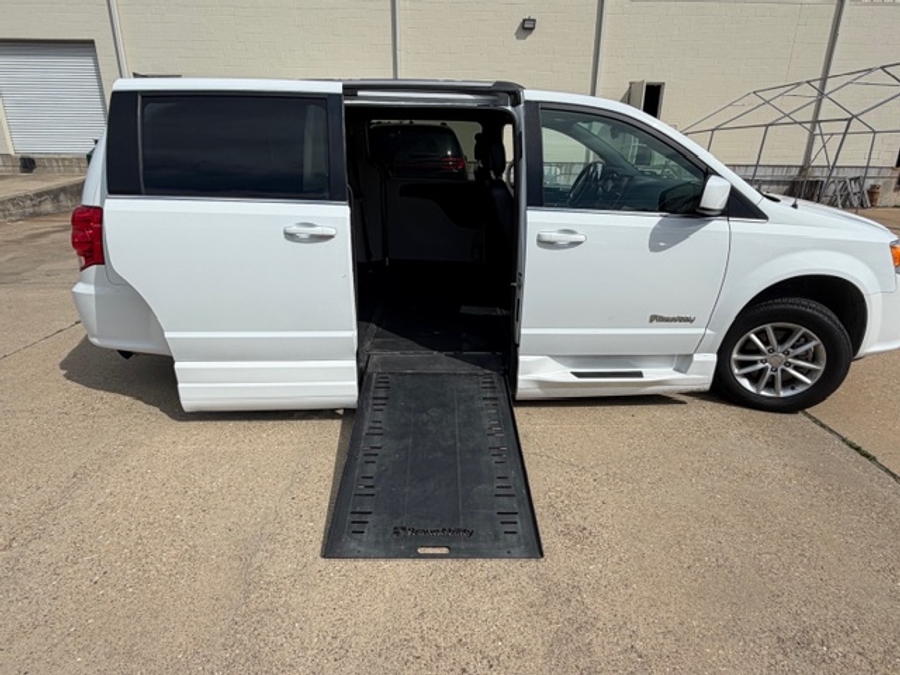 Dodge Grand Caravan blanco con rampa de plegado automático de entrada lateral