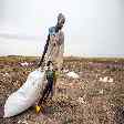 Mulher arrasta saco de comida jogado do alto pelo Programa Mundial de Alimentos no Sudão do Sul 