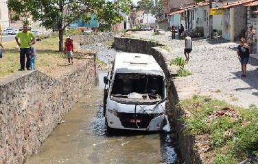Para não colidir em moto, motorista de ônibus desvia e cai em canal