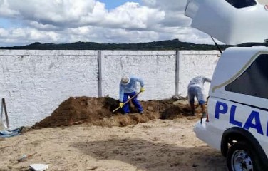 Funcionários da prefeitura fazendo a cova no cemitério da cidade