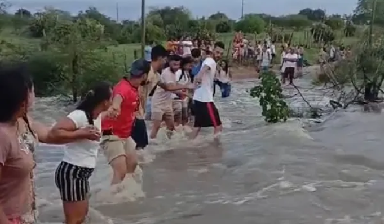 Ontem, moradores chegaram a formar um cordão humano para ajudar estudantes a atravessar uma estrada tomada pela correnteza