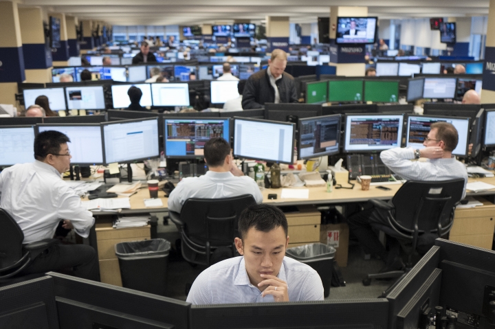 In this Jan. 12, 2017, photo, traders work on the Mizuho Americas trading floor in New York. Global stock markets traded on a soft note Wednesday, March 8, 2017, after Wall Street fell for a second day following U.S. President Donald Trump's comments about reducing drug prices. (AP Photo/Mark Lennihan)