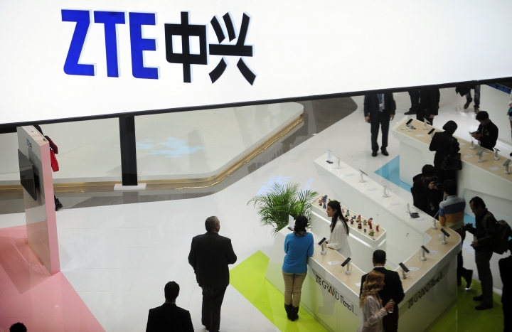 FILE - In this Wednesday, Feb. 26, 2014, file photo, people gather at the ZTE booth at the Mobile World Congress, the world's largest mobile phone trade show in Barcelona, Spain. Shares in ZTE Corp. have fallen 42 percent in Hong Kong after the Chinese telecoms equipment maker agreed to pay a $1 billion penalty to the U.S. government and replace its top managers. (AP Photo/Manu Fernandez, File)
