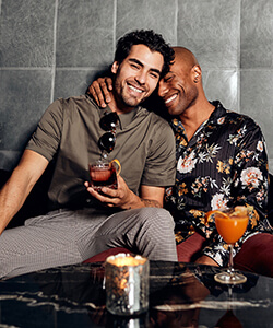 two men sitting and drinking cocktails