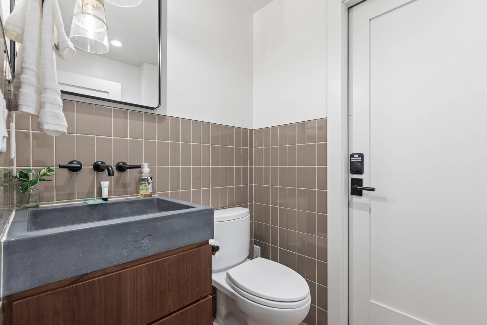 Sleek toilet and sink in modern bathroom setting.