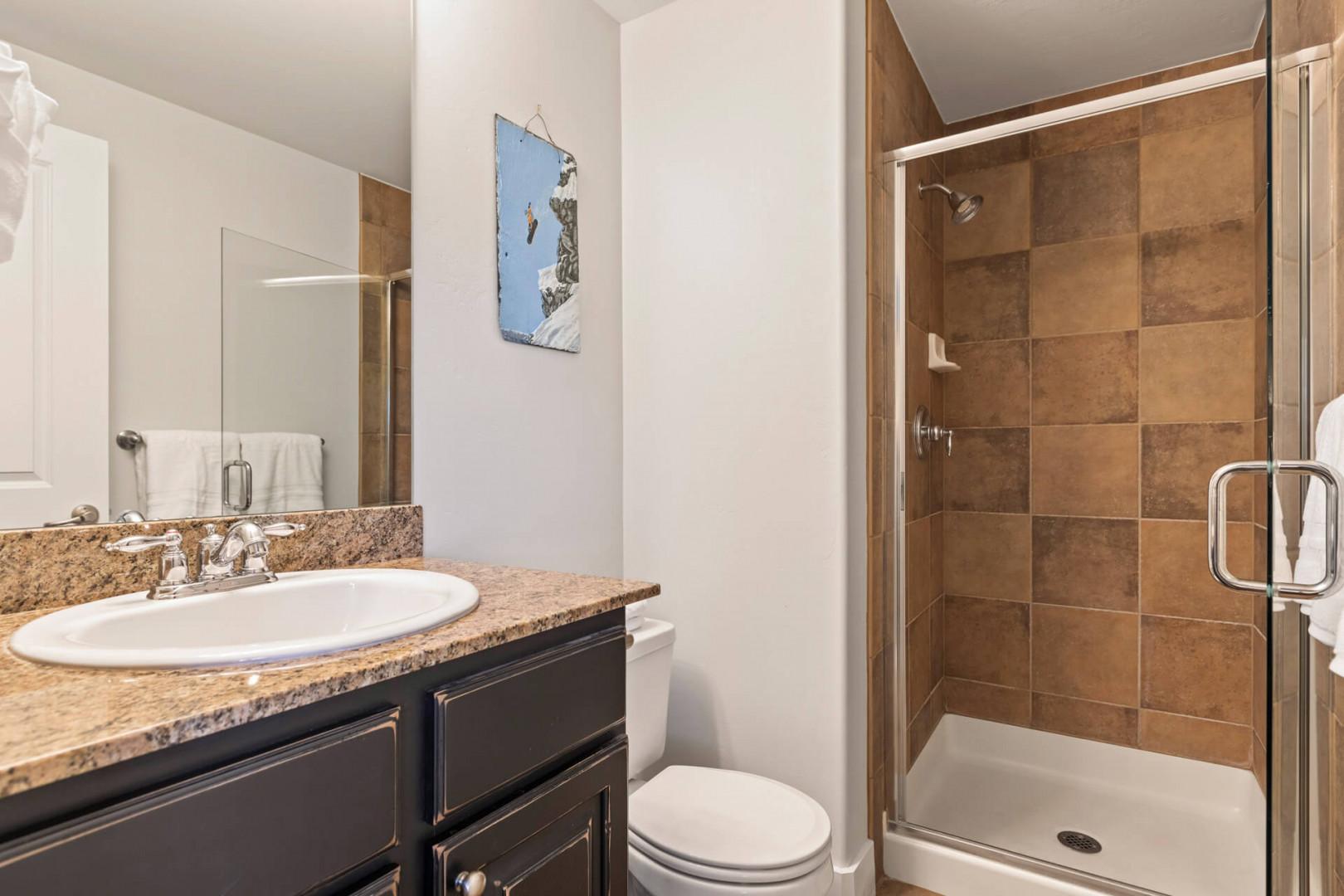 Bear Hollow Village 5595: Sleek sink, mirror, toilet, and shower in modern design.