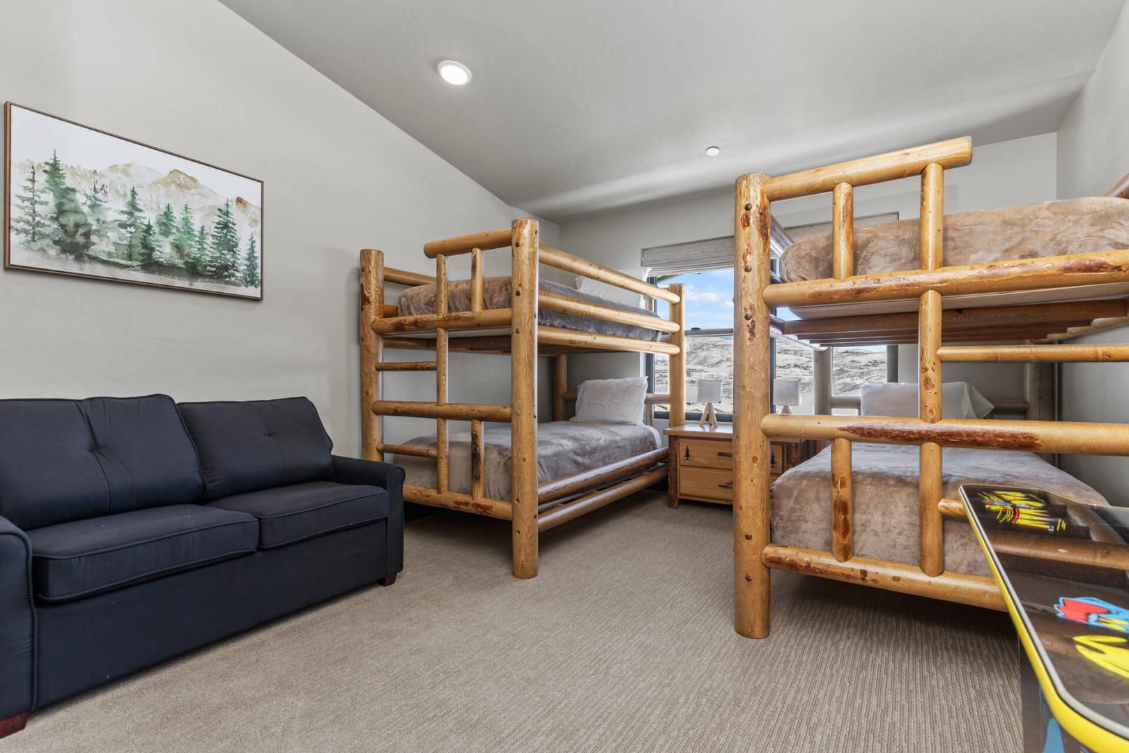 Cozy space with two bunks and a comfy sofa.