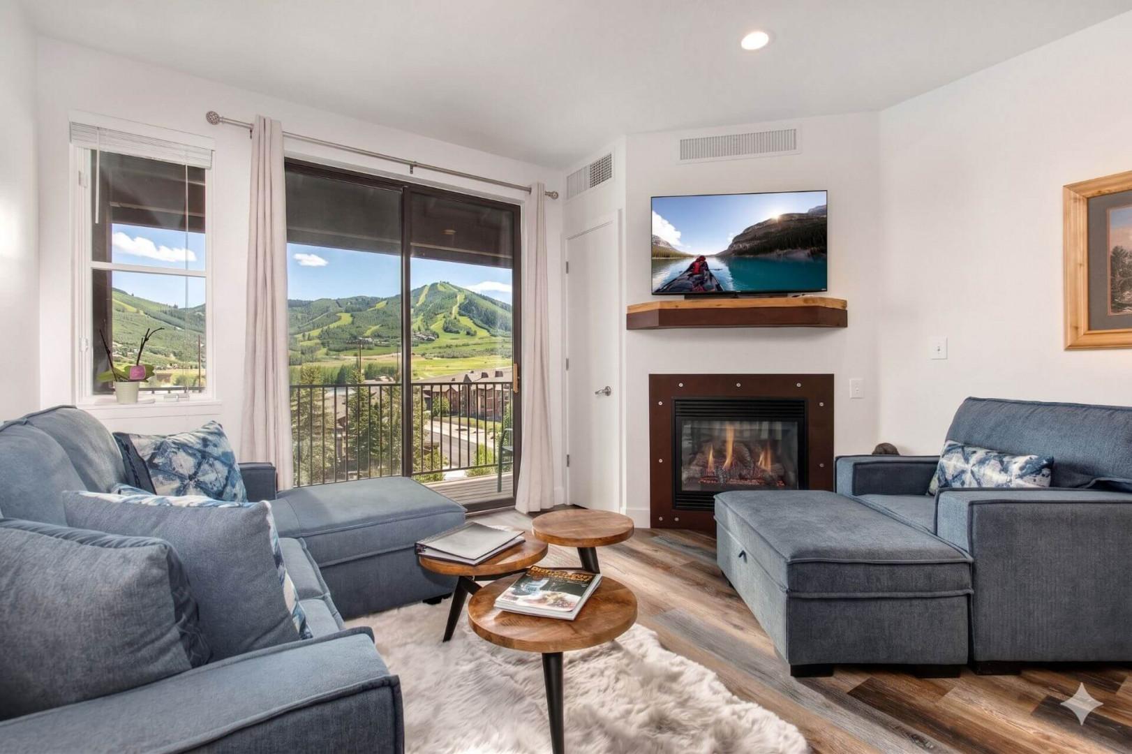 Unwind on plush sofas while soaking in breathtaking mountain views through floor-to-ceiling windows. Cozy up by the fireplace or catch your favorite show on the mounted TV—your alpine retreat awaits.