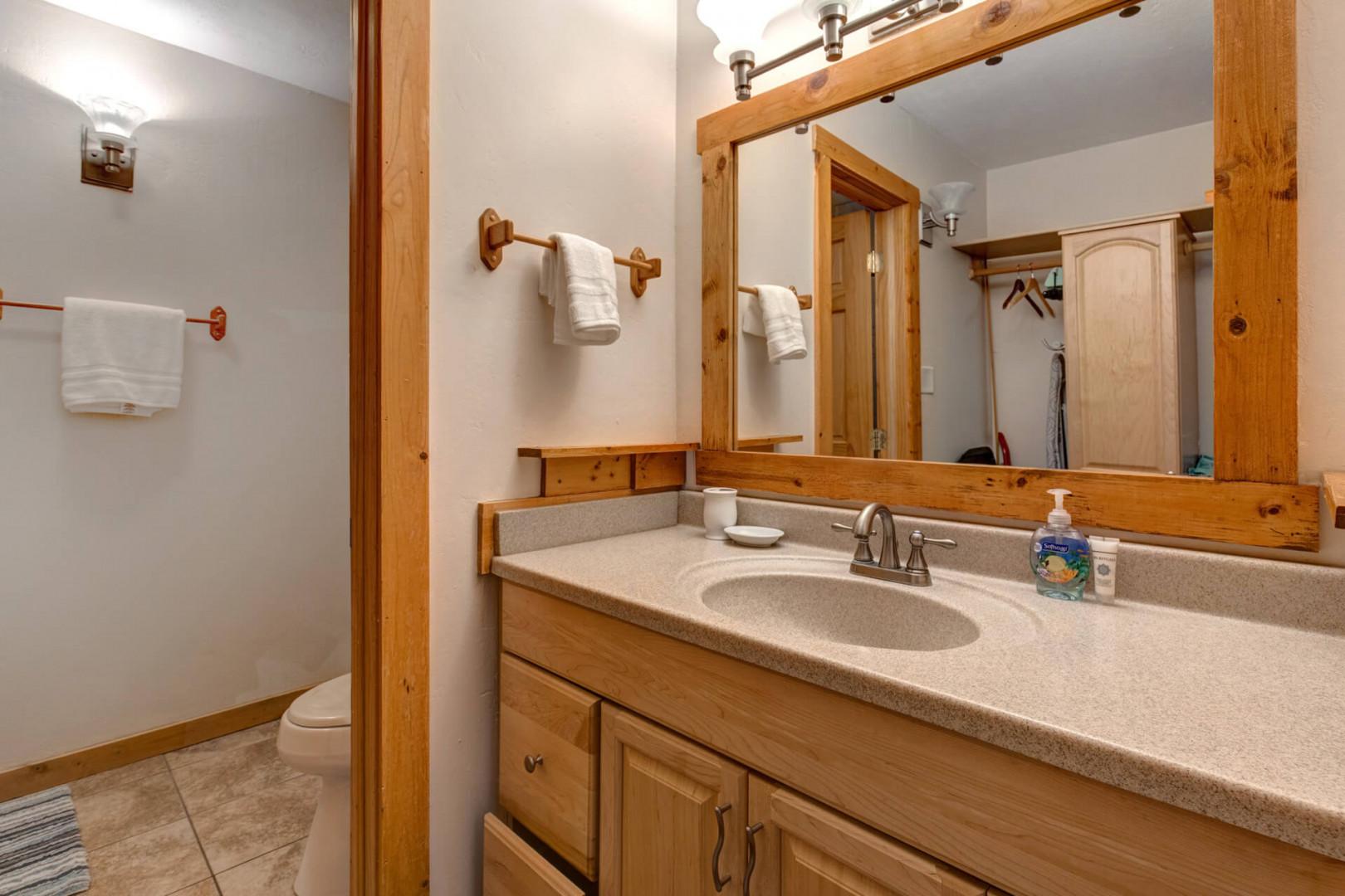 Bathroom: "Sleek sink, cabinet, mirror, and bright overhead light fixture."