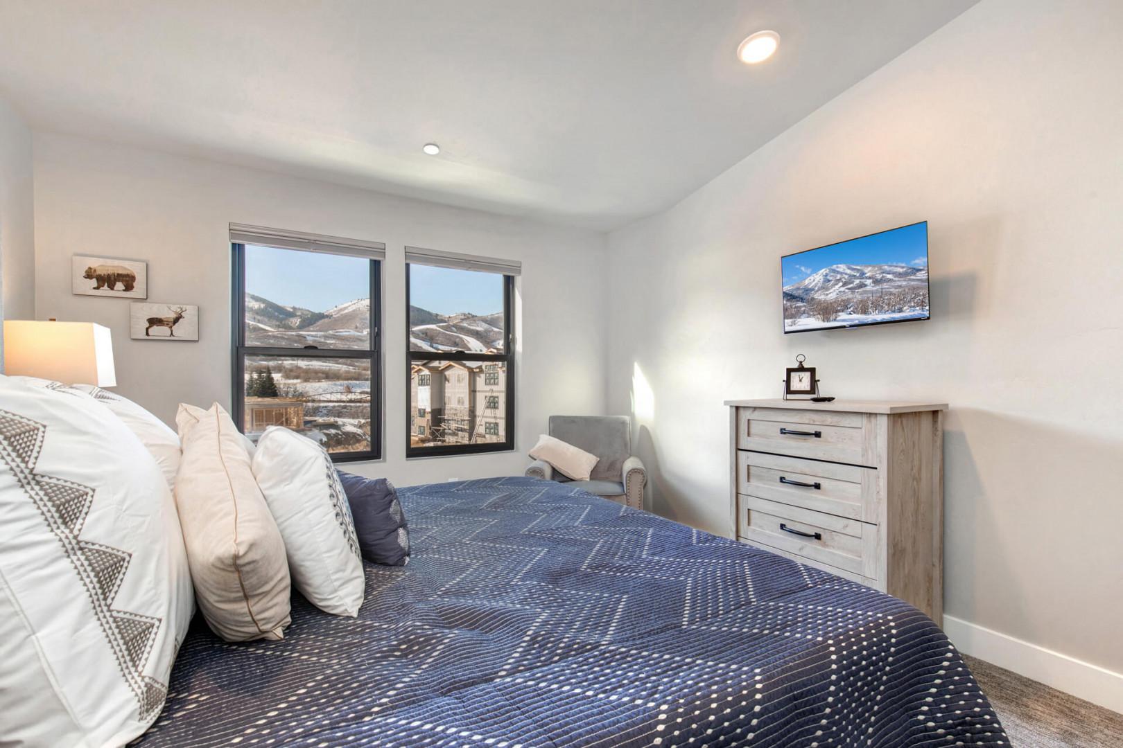 Cozy space with a bed, window view, and comfy sofa chair.