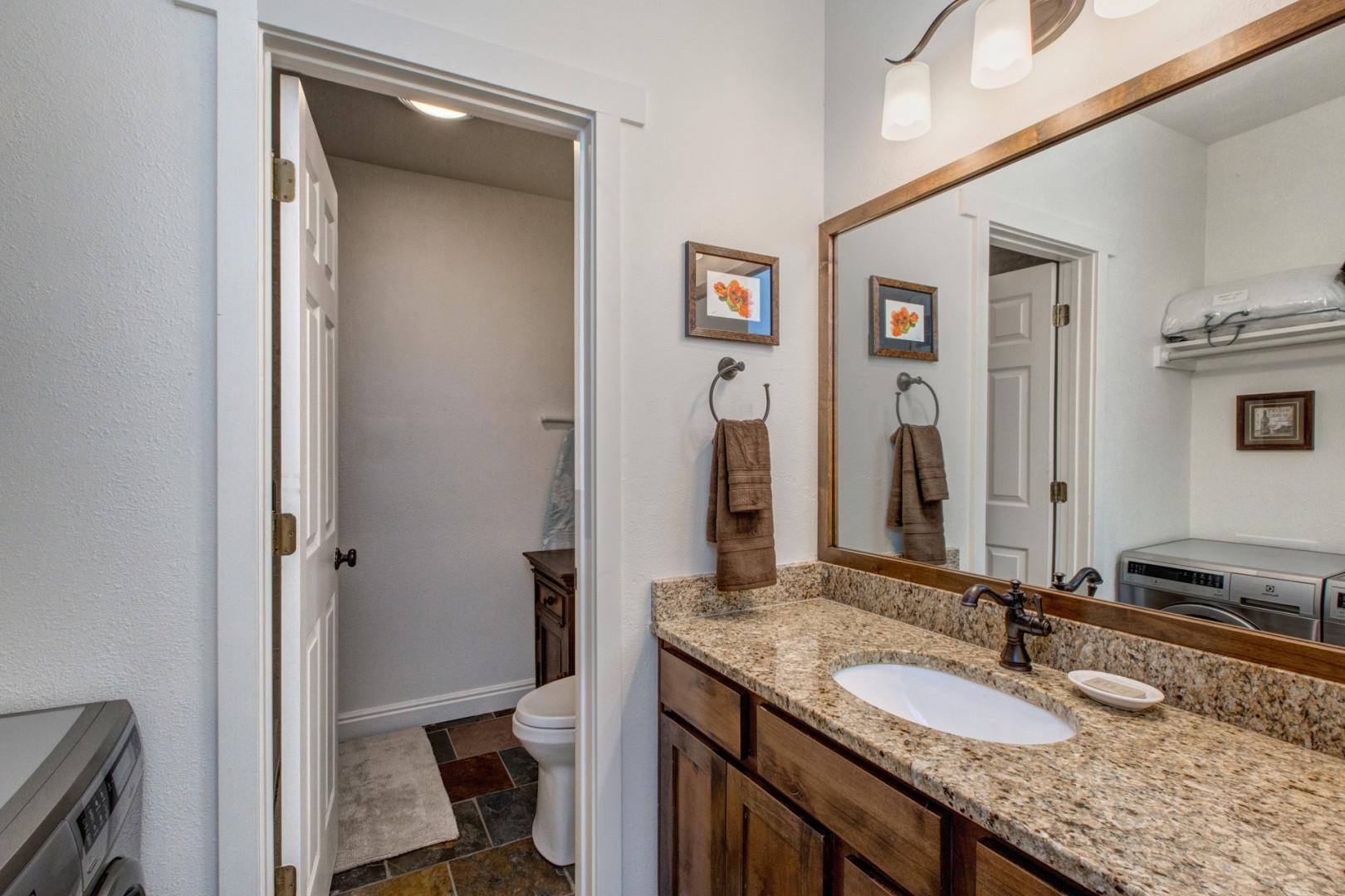 Sleek sink, mirror, toilet, in modern design.