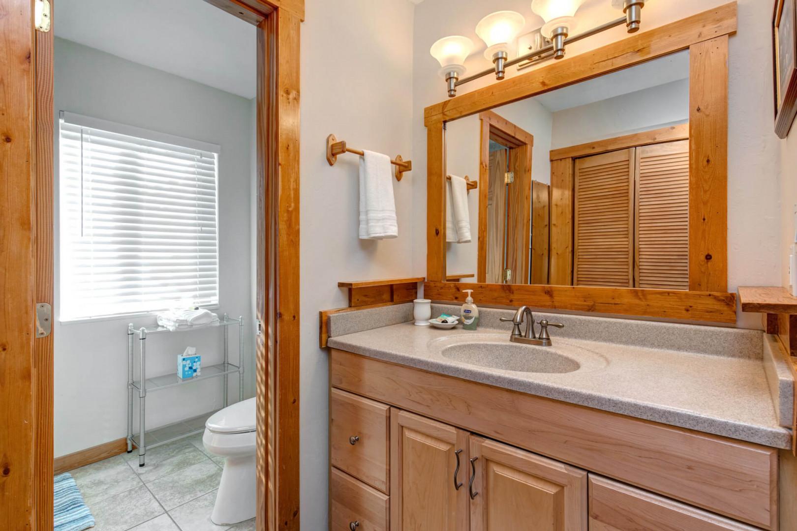 Bathroom: "Sleek sink, cabinet, mirror, and bright overhead light fixture."