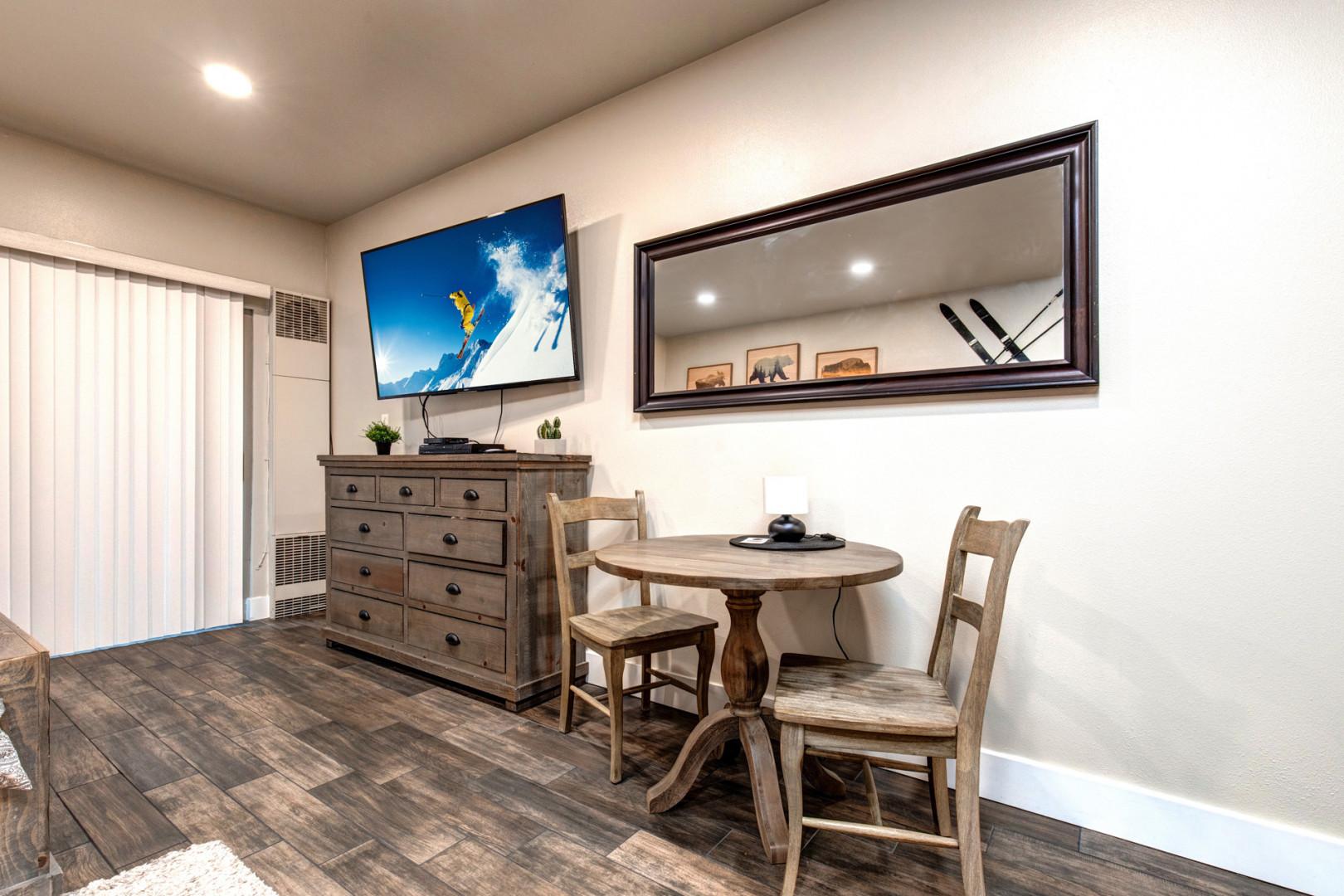 Modern dining table with overhead mirror TV creating a stylish ambiance.