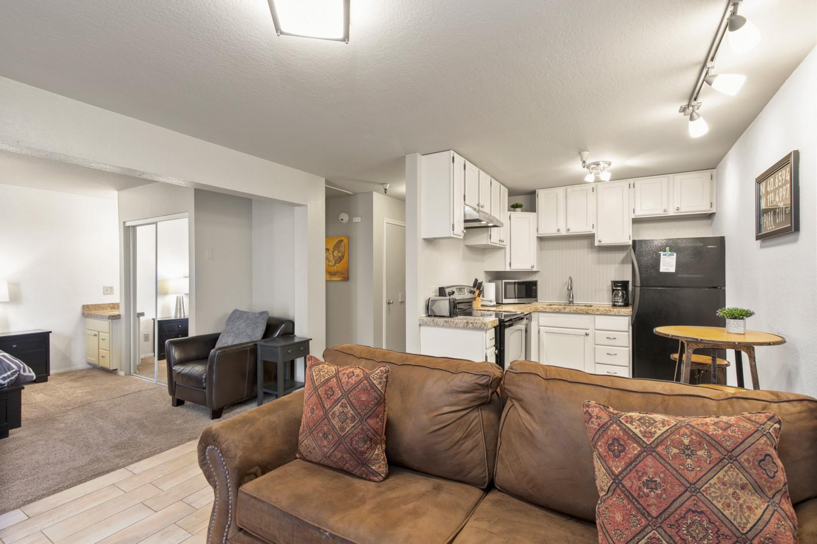 Cozy sofa with a view of the kitchen in the background.