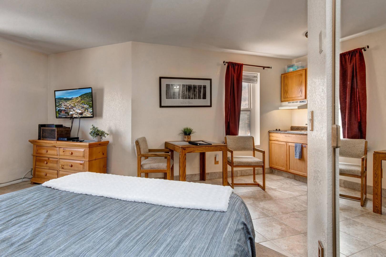 Cozy queen bed with a view of the kitchen.