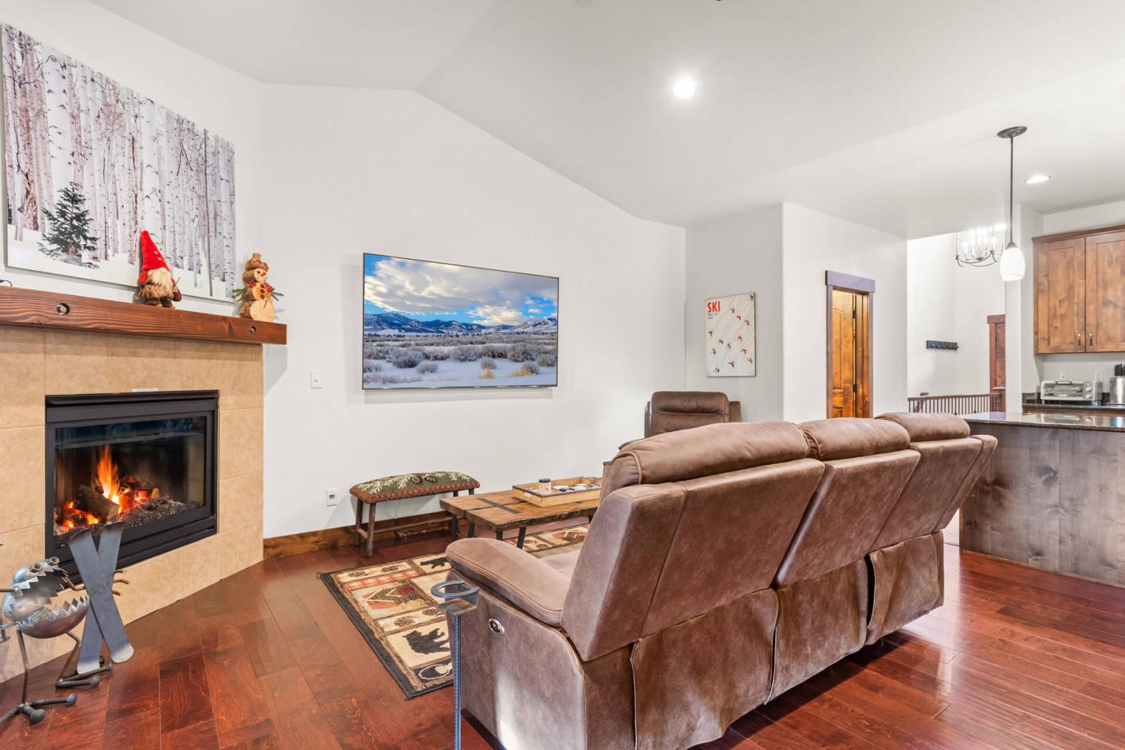 Sink into plush leather seating by your crackling fireplace, where mountain views on screen complement cozy evenings in this inviting living space.
