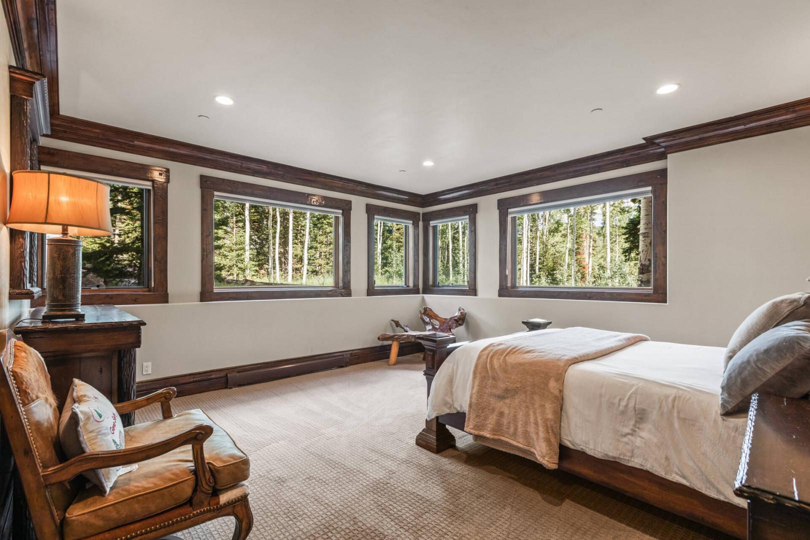 Cozy bed framed by sunlight-filled windows, perfect for lazy mornings.