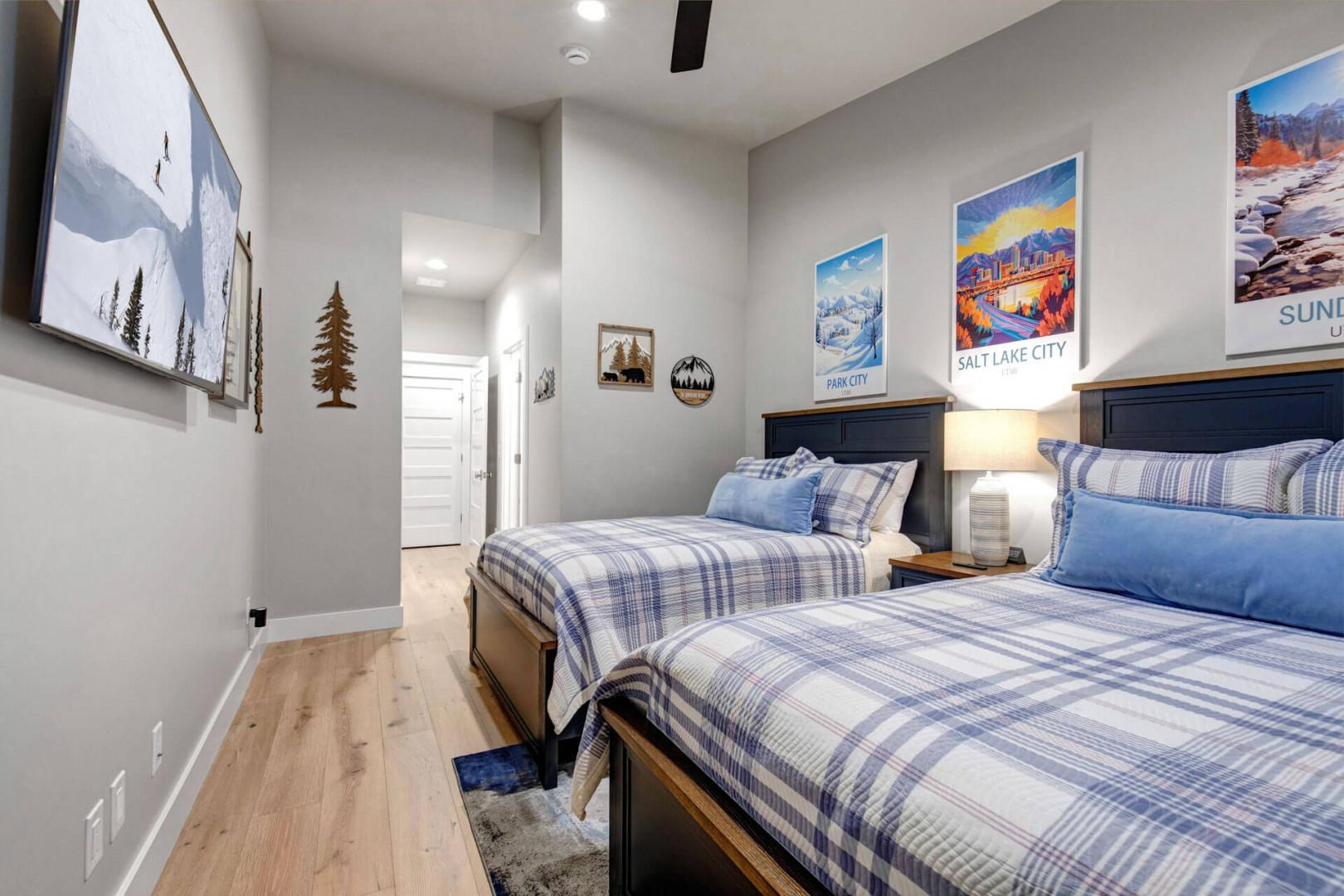 Drift off in this cozy mountain-themed bedroom, where two plush beds invite you to unwind after a day of adventure. The cheerful blue linens and warm wood accents create a serene retreat just for you.