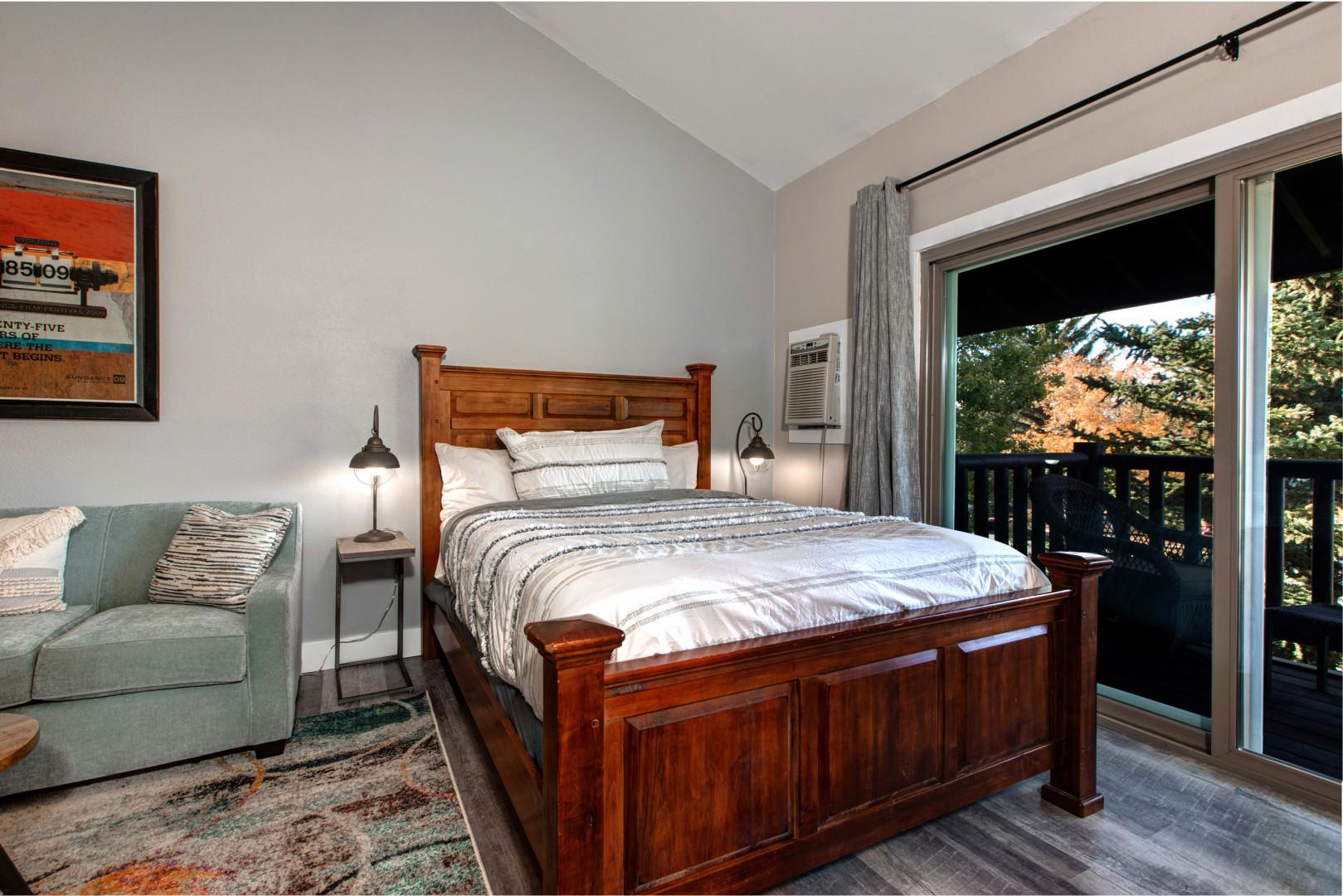 Cozy queen bed with access to a charming outdoor patio area.