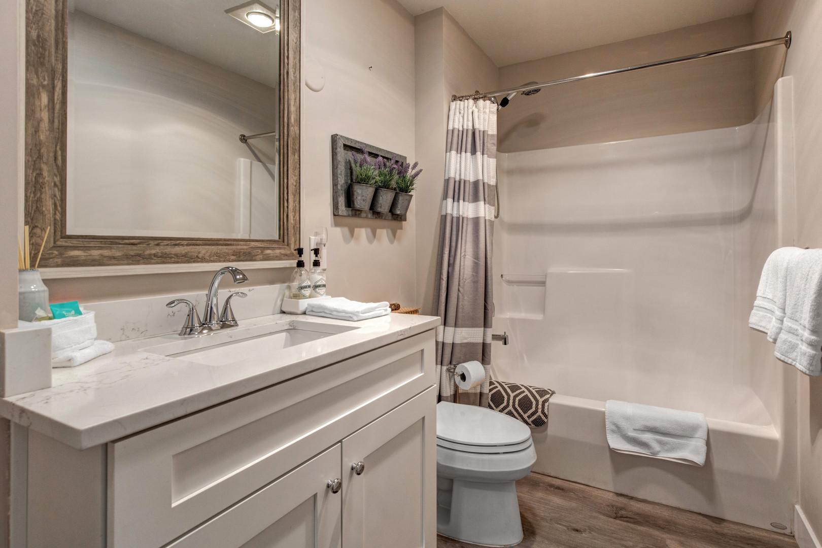 Stillwater 3067: Sleek sink, mirror, toilet, and convenient tub shower combo.