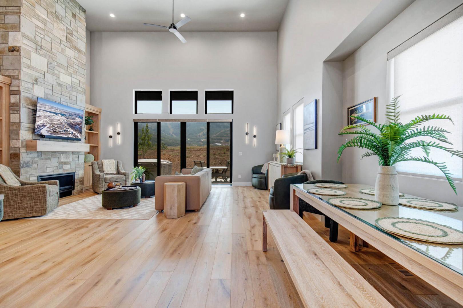 Gather in this open-concept living space where soaring ceilings and floor-to-ceiling windows frame stunning mountain vistas. Cozy up by the stacked-stone fireplace or settle in around the handcrafted dining table for memorable meals together.