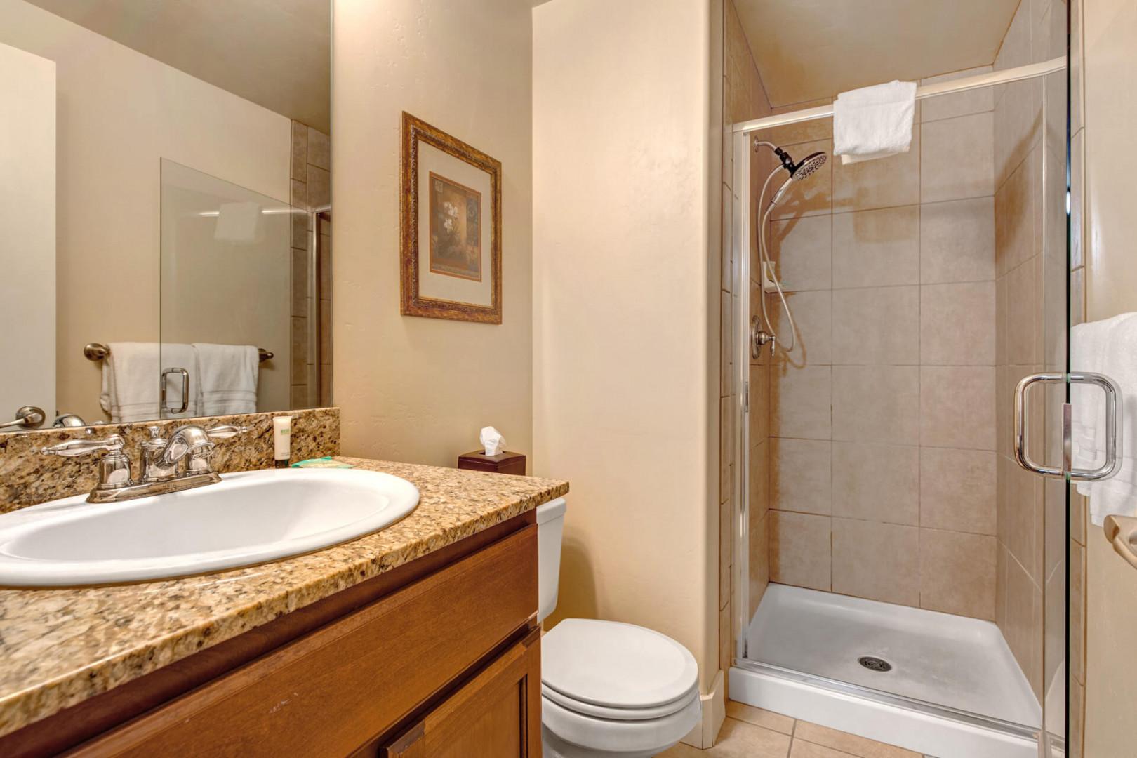 Step into your elegant bathroom featuring granite counters and a refreshing glass-enclosed shower to start your day perfectly.