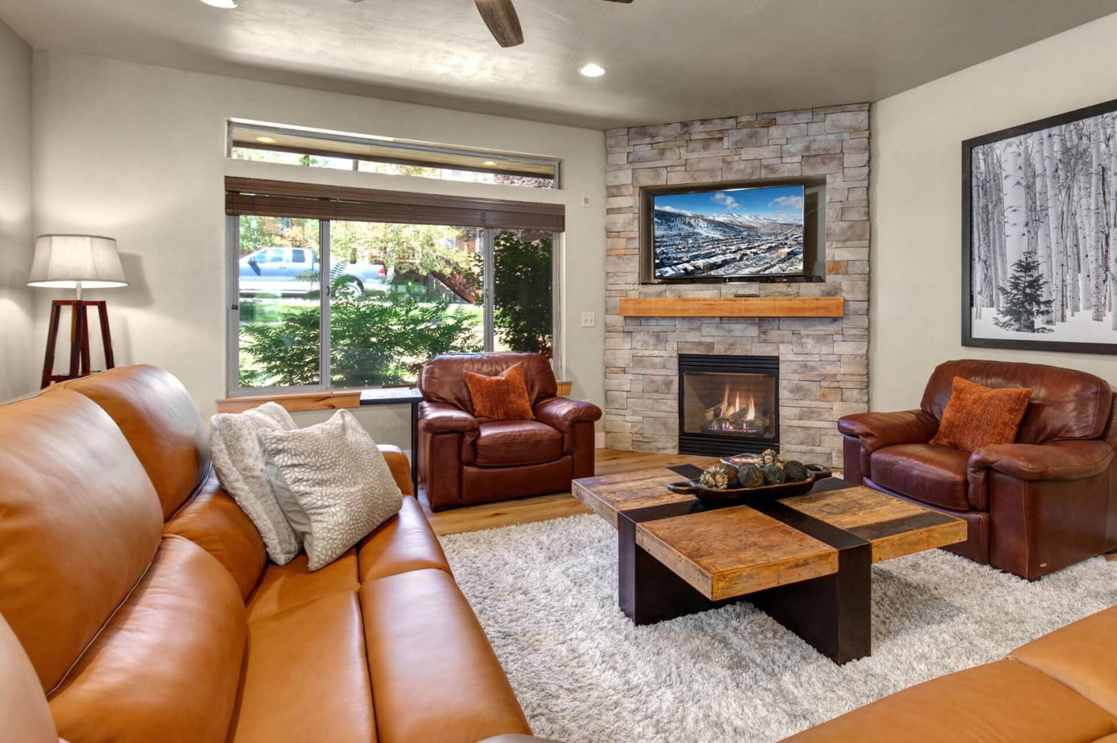 Sink into plush leather seating while the fireplace crackles warmly. Your mountain retreat features stunning views and cozy elegance.