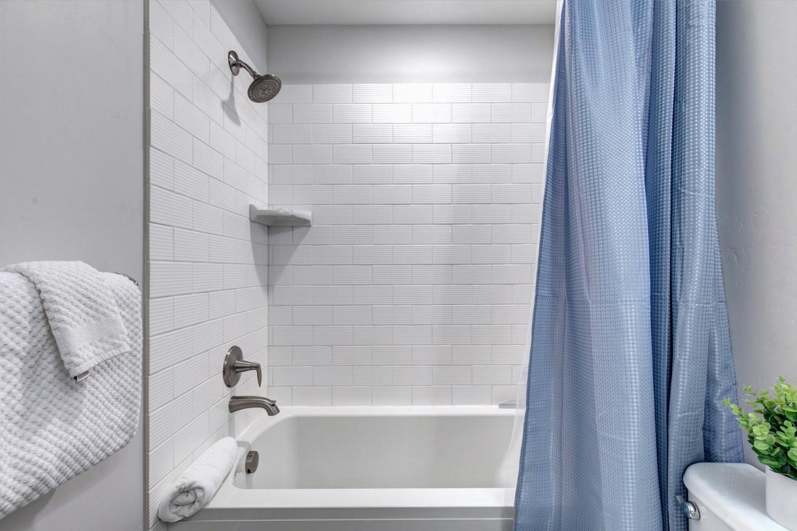 Step into your serene bathroom, where crisp white subway tile and a fresh curtain create a bright, calming space to refresh and unwind.