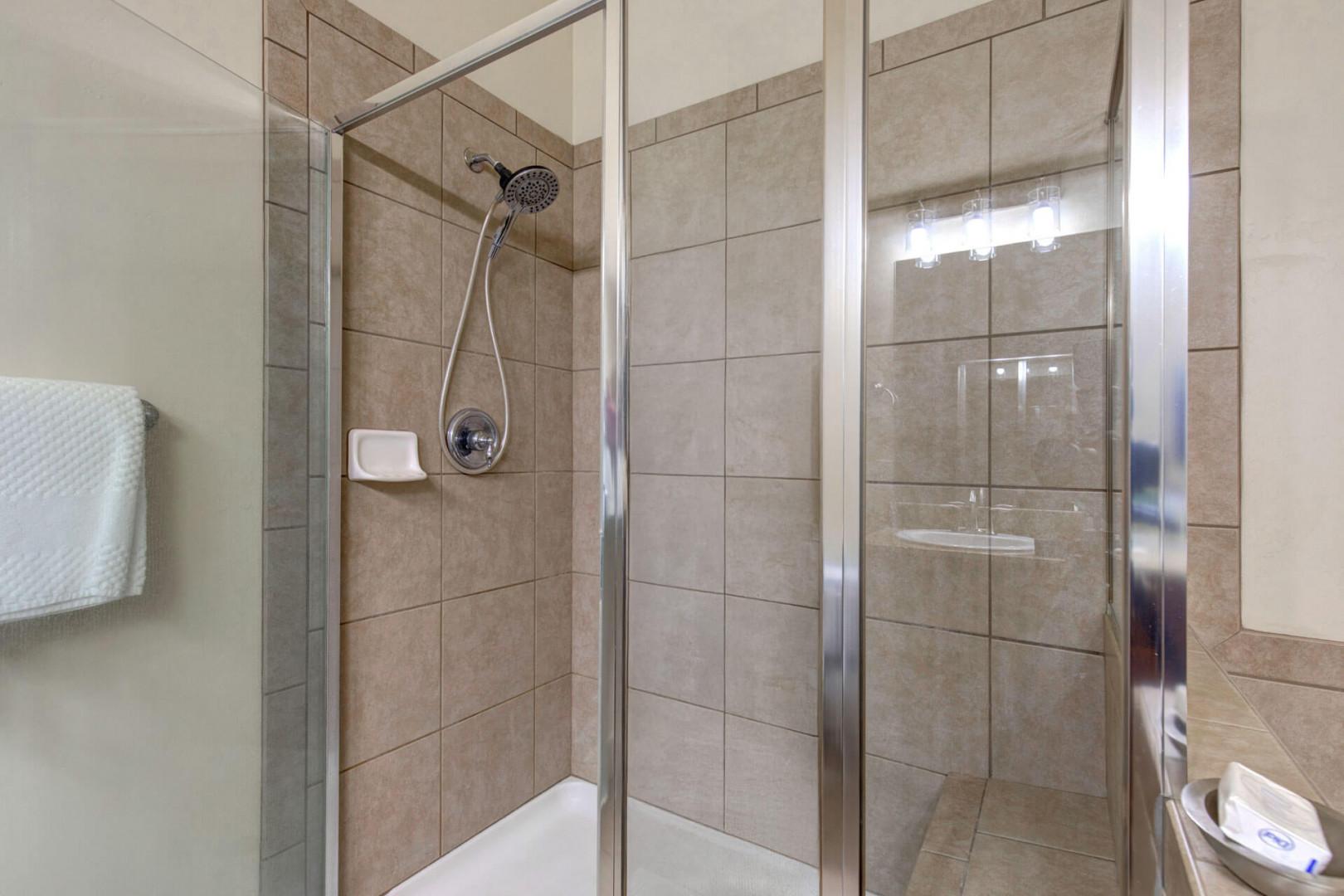 Step into your private spa-like shower with elegant stone tiles and rainfall showerhead for the perfect refreshing start to your day.