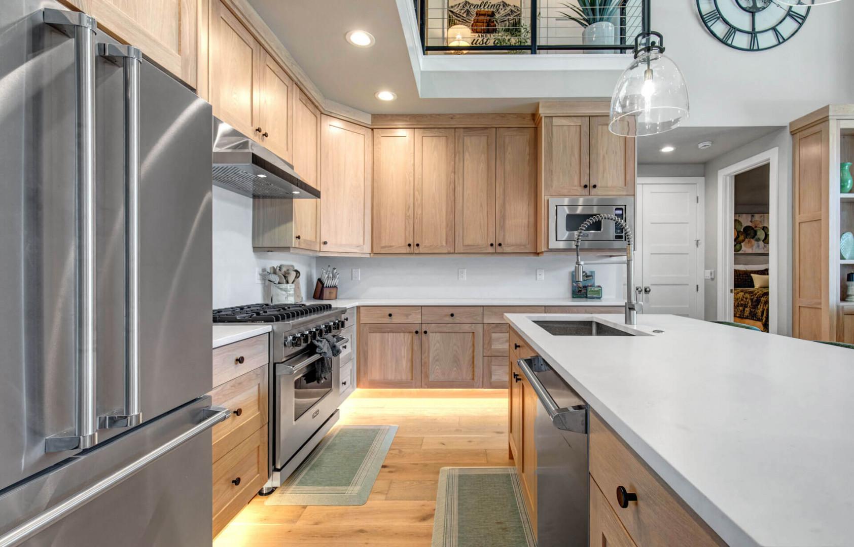 You'll love cooking in this bright, airy kitchen with its gleaming appliances, spacious island, and warm wood cabinetry—a chef's dream setup for your vacation meals.