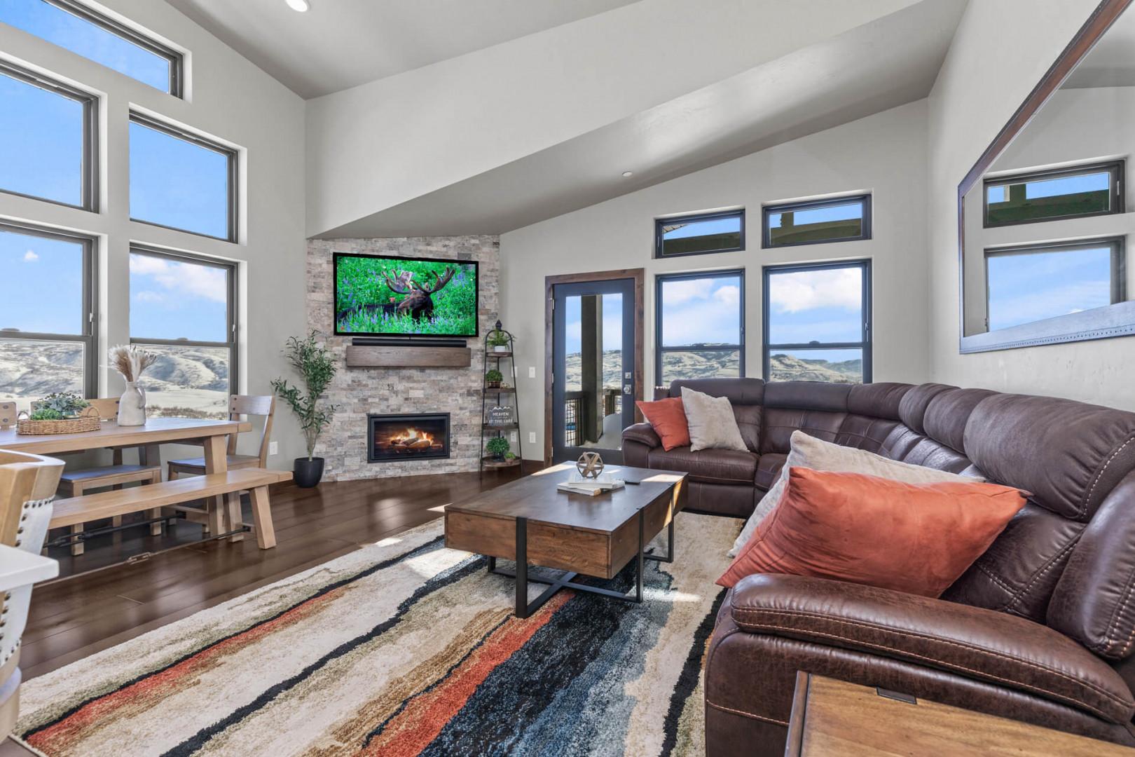 Cozy space with a fireplace, sofa set, and views from windows.