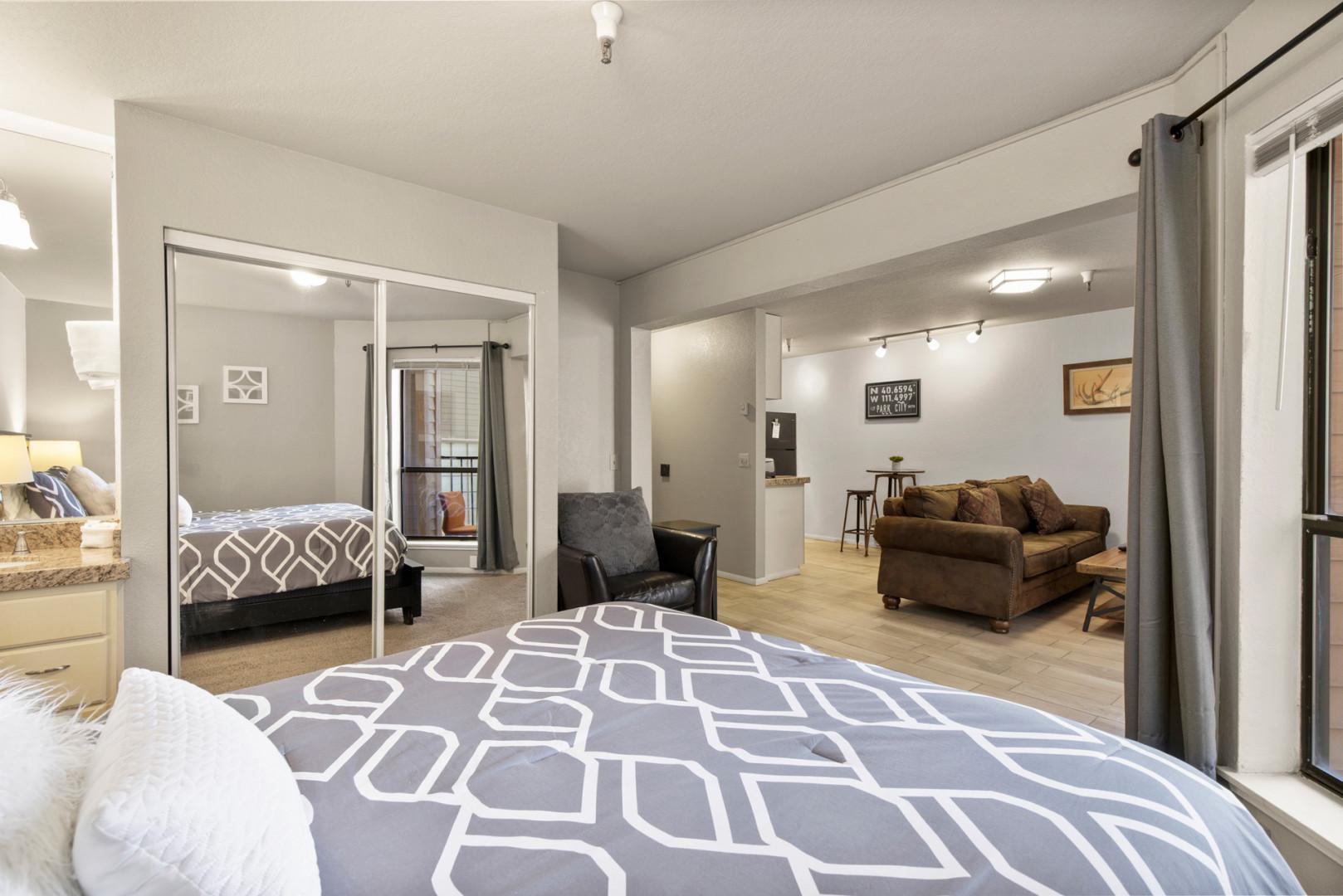 Cozy queen bed offers a view of the inviting living room.