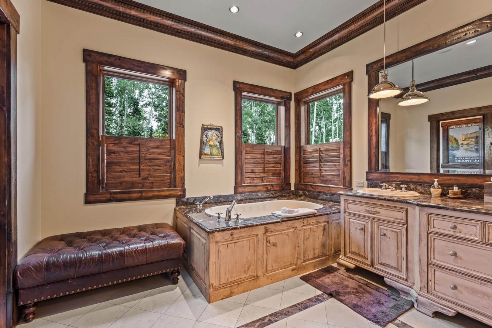 Relaxing bath tub, sleek sink, and mirror make a perfect trio.