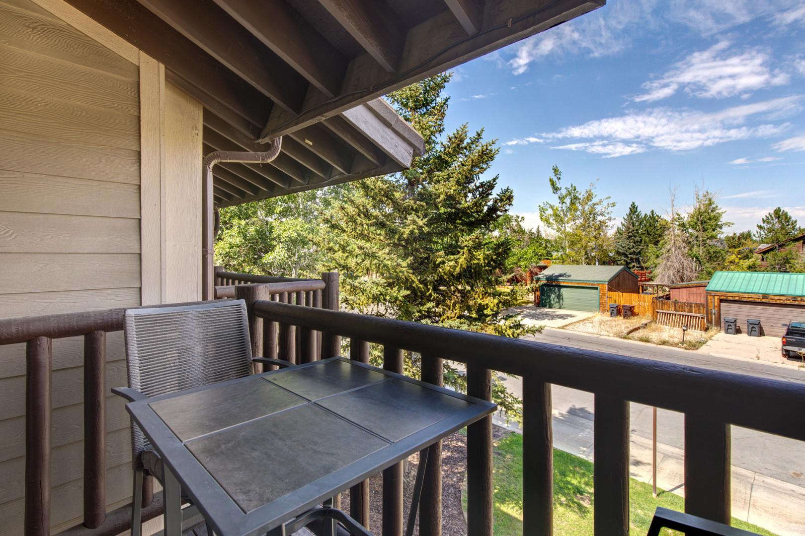 Relax in nature's embrace with two chairs and a cozy table.