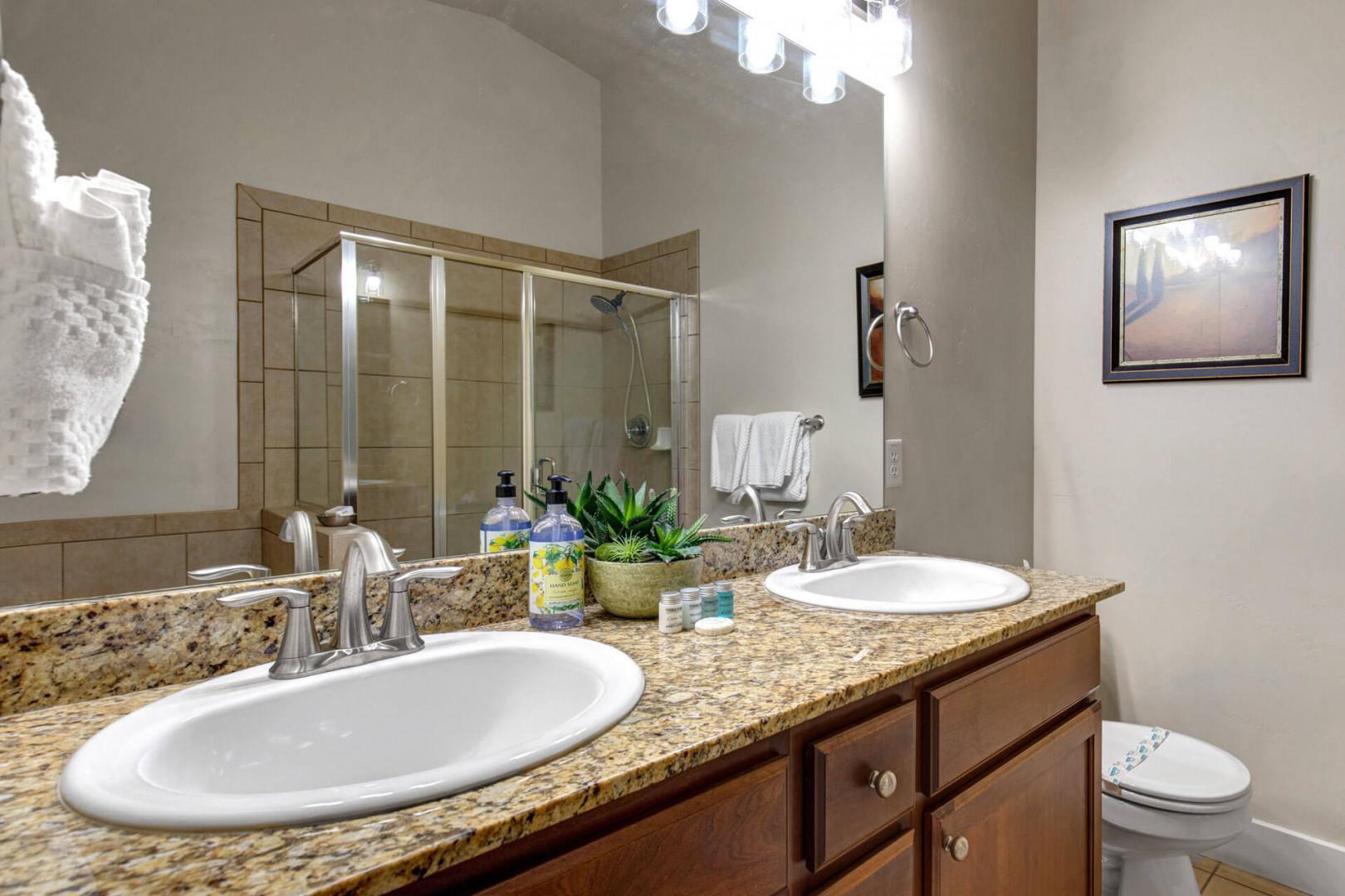 Step into your beautifully appointed bathroom with dual vanities, granite counters, and a spacious glass shower for refreshing mornings.