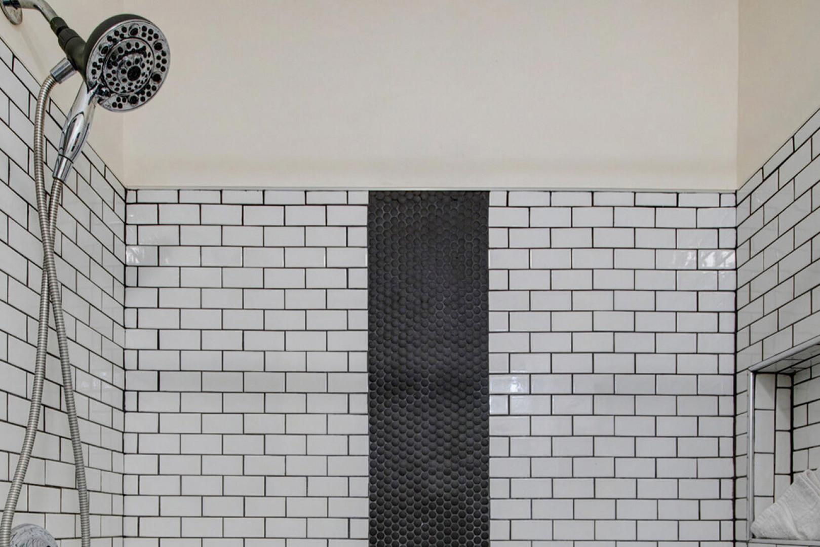 Step into your private shower with crisp white subway tiles and sleek black accents, where a refreshing rinse awaits after a day of adventure.