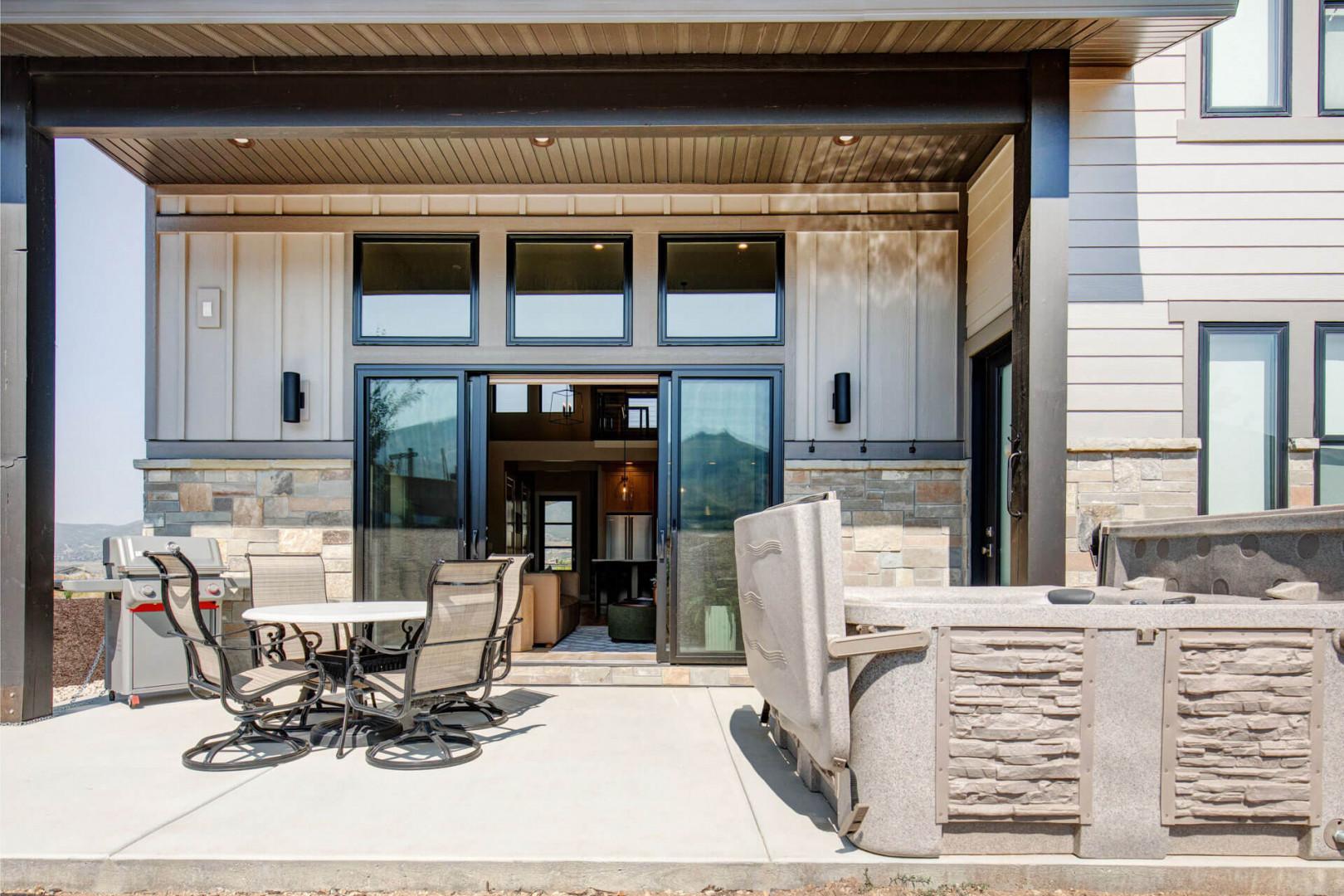 Your private outdoor living area awaits, complete with a covered patio, dining space, and mountain views framing every moment of relaxation.