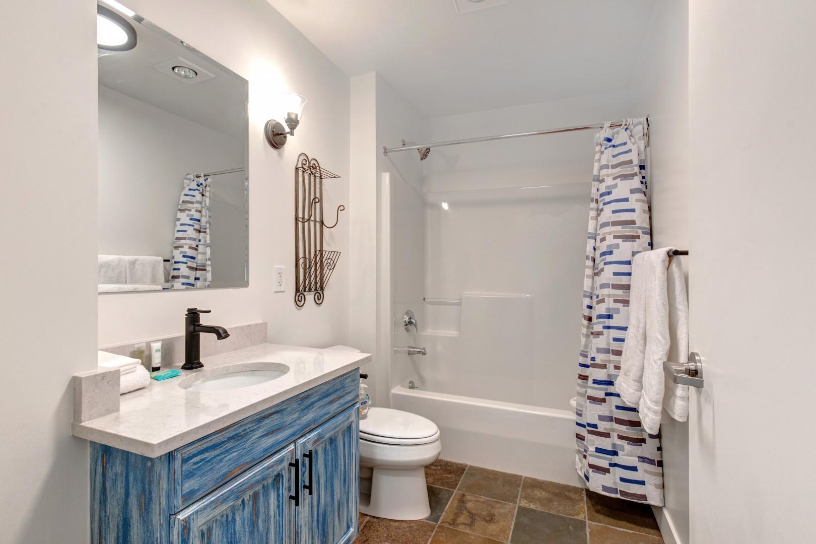 Stillwater #3011_13: Sleek sink, mirror, toilet, and convenient tub shower combo.