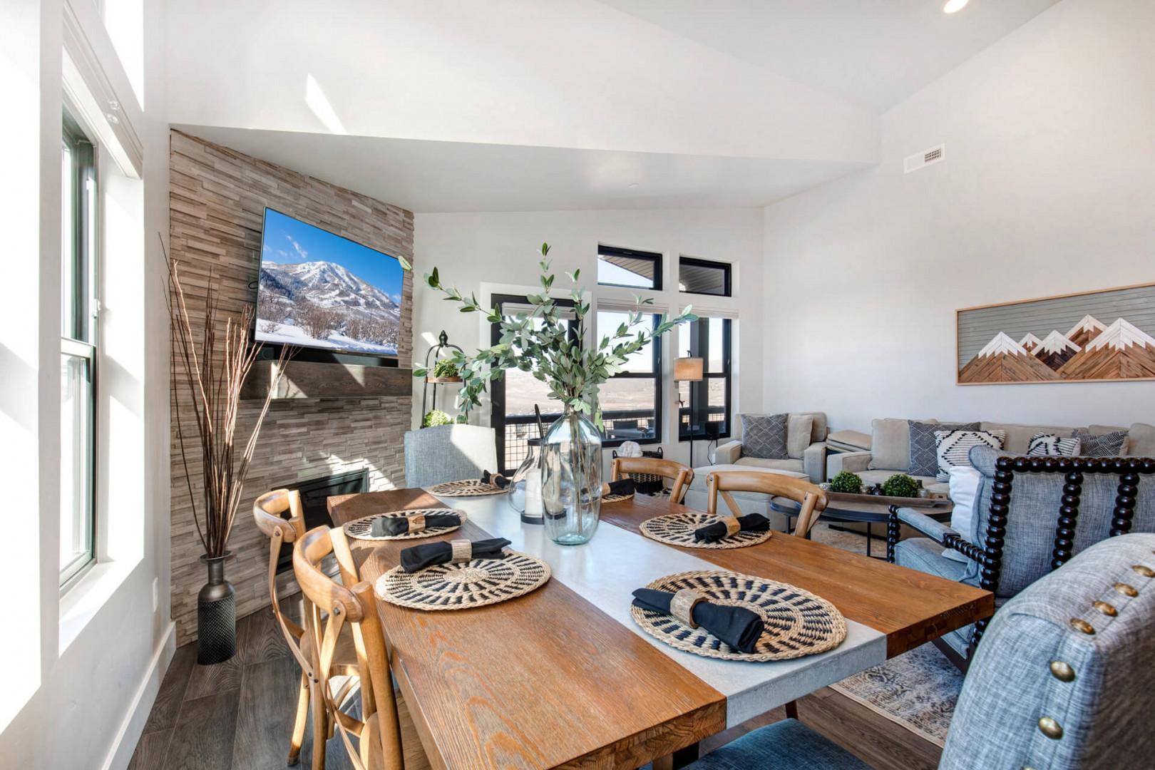 Cozy space with a dining table, fireplace, sofa set, and windows.